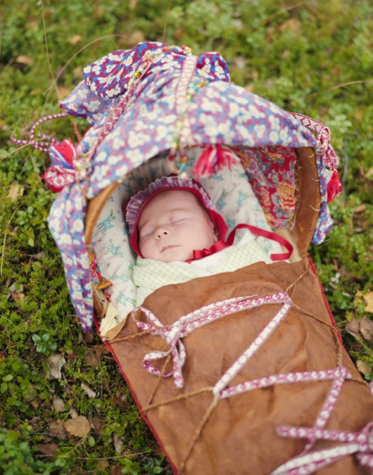 A sleeping baby in a traditional Saami cradle